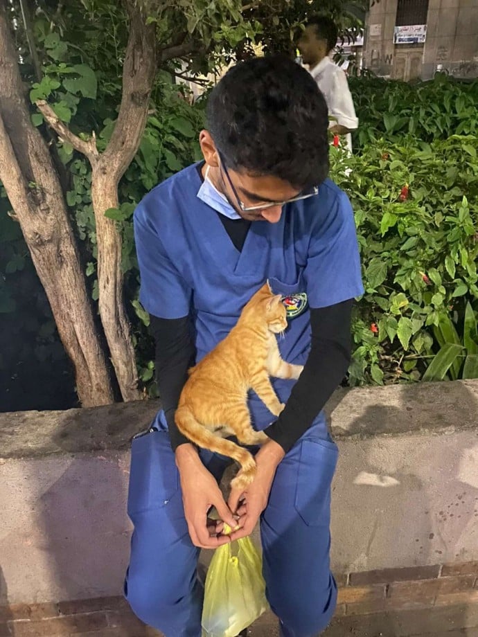 An exhausted nurse on his break is comforted by a stray cat 4