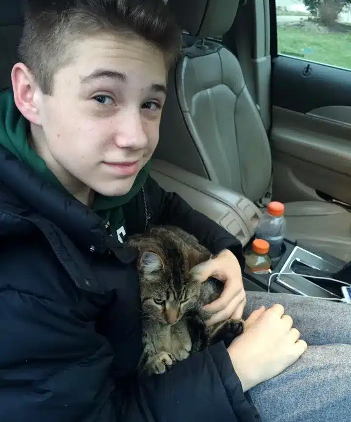The cat clings on the 14-year-old boy for dear life when he dives into the overpass to save it from the bridge 1